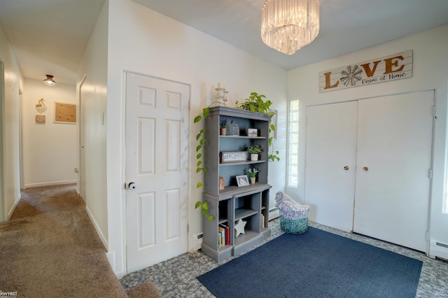 carpeted foyer entrance featuring a notable chandelier, baseboards, and a baseboard radiator