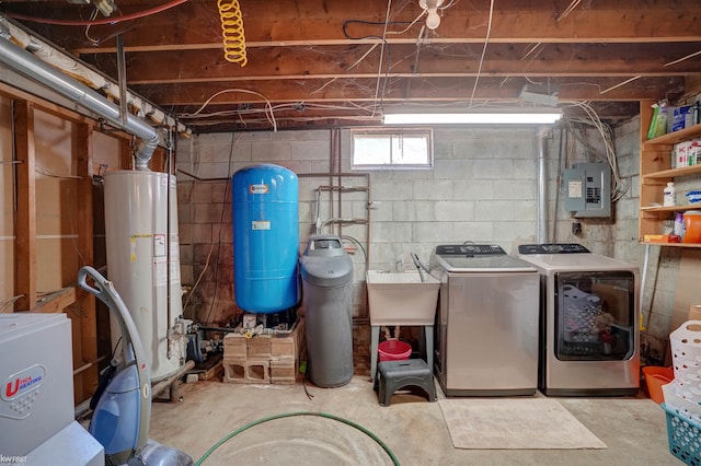 interior space featuring water heater, laundry area, electric panel, washer and dryer, and a sink