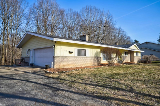 ranch-style home featuring driveway, brick siding, a chimney, a front lawn, and board and batten siding