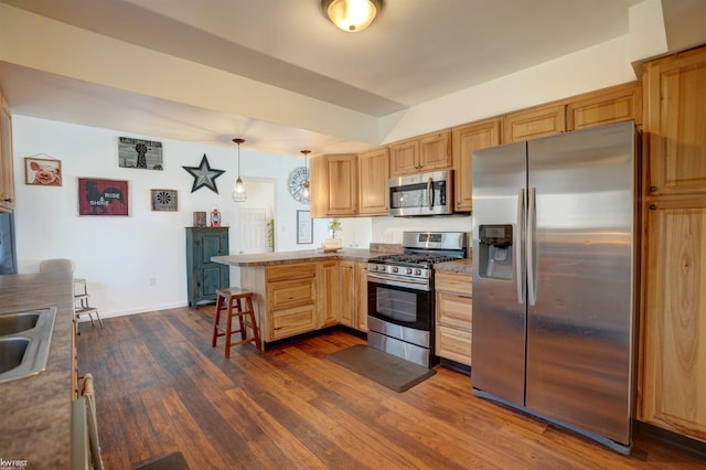 kitchen with a breakfast bar area, dark wood-style flooring, a peninsula, stainless steel appliances, and a sink