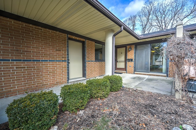 view of exterior entry with brick siding