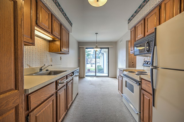 kitchen with white appliances, wallpapered walls, a sink, light countertops, and light carpet