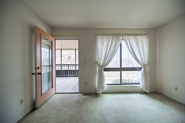 carpeted empty room with visible vents and baseboards