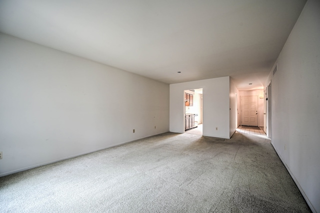 empty room featuring visible vents and light carpet