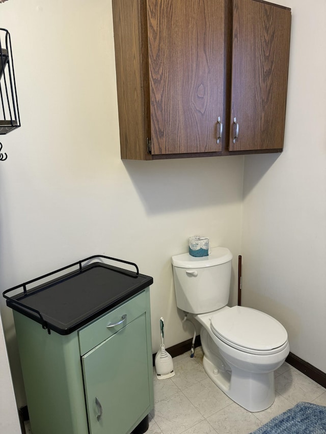 half bath with baseboards and toilet