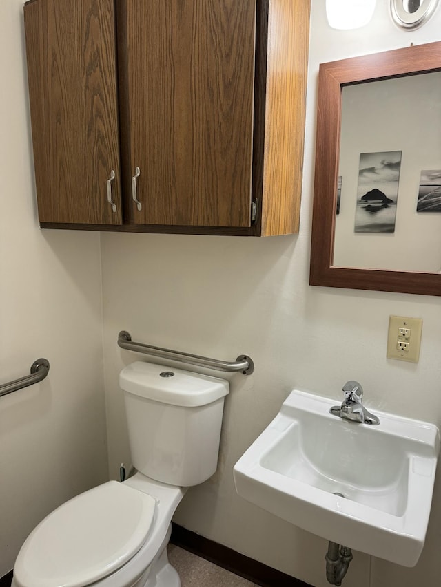 half bathroom featuring a sink and toilet