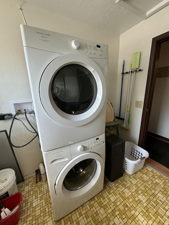 laundry room with laundry area, a textured ceiling, and stacked washer and dryer