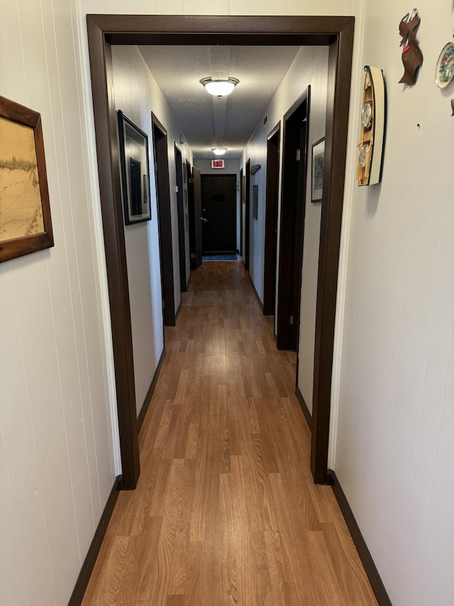 hallway with wood finished floors and baseboards