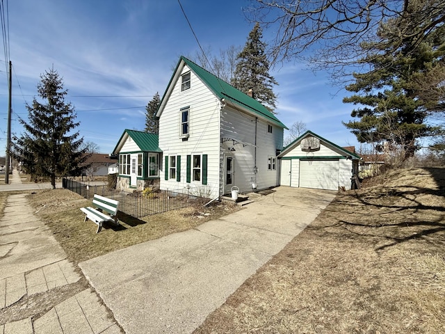 view of front of property featuring metal roof, a detached garage, an outdoor structure, and fence