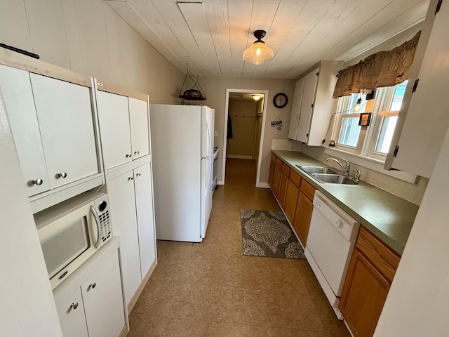 kitchen featuring a sink, white appliances, light floors, and brown cabinetry