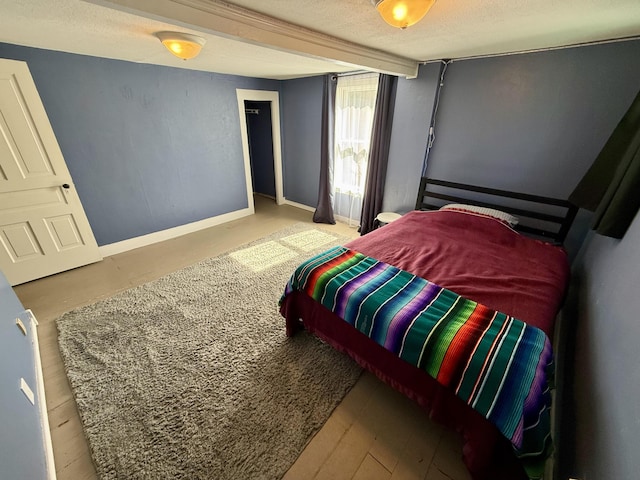 bedroom with baseboards and a textured ceiling