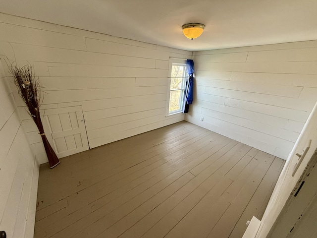 empty room with wooden walls and wood finished floors