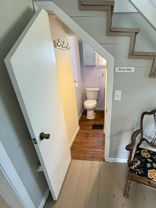 bathroom with visible vents, wood-type flooring, toilet, and baseboards