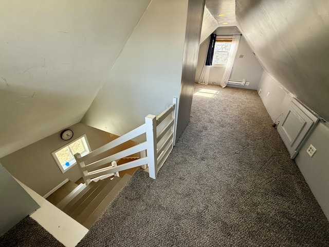 interior space with a baseboard heating unit, lofted ceiling, and carpet floors