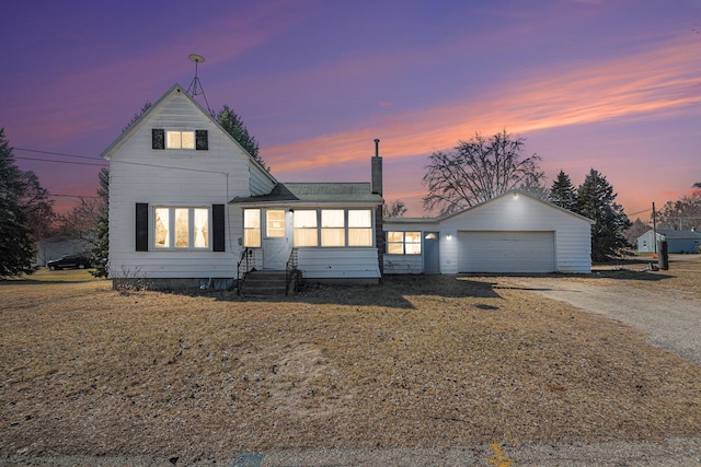 traditional-style house featuring entry steps, a garage, and dirt driveway