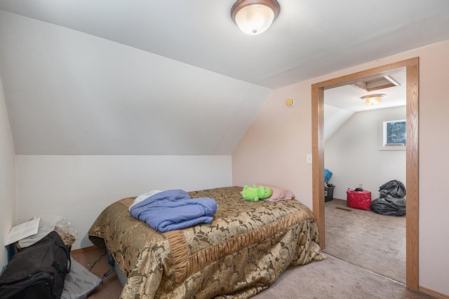 carpeted bedroom with lofted ceiling and attic access