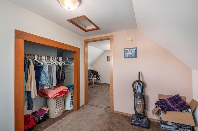 interior space with baseboards, attic access, vaulted ceiling, carpet flooring, and a closet