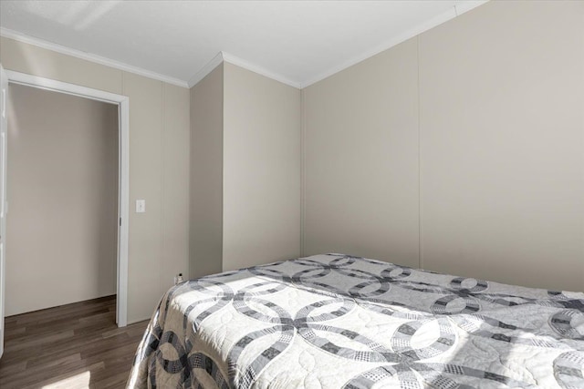 bedroom with crown molding and wood finished floors