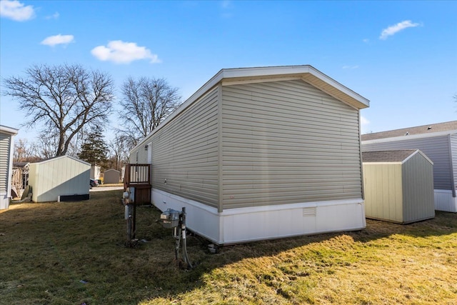 view of side of home with an outbuilding, a yard, and a storage unit