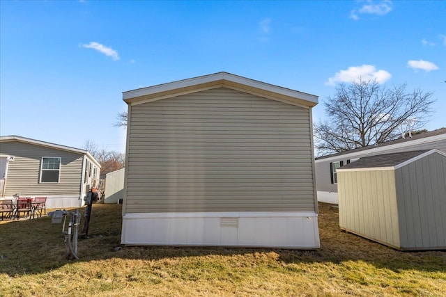 view of side of property with an outbuilding, a shed, and a yard