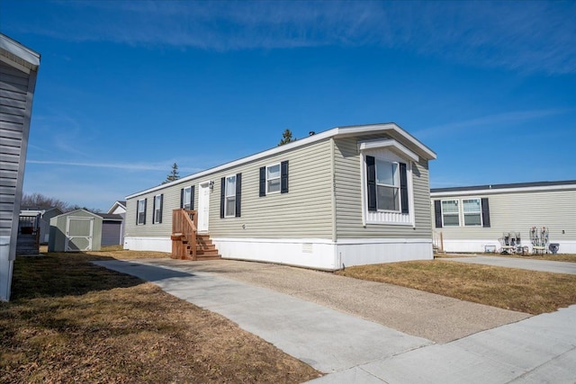 manufactured / mobile home with a storage shed and an outbuilding