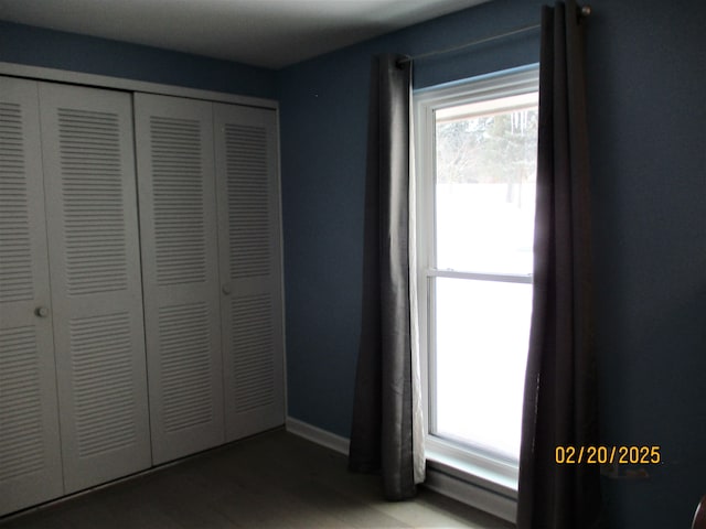 unfurnished bedroom with a closet, baseboards, and wood finished floors