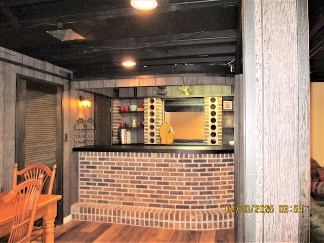 wine area featuring wood finished floors and a dry bar