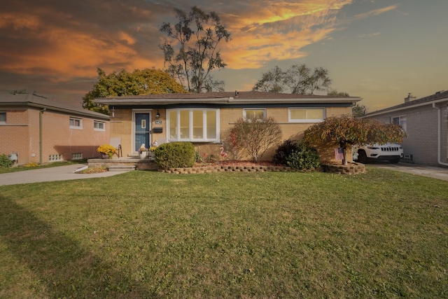 single story home featuring brick siding and a front yard