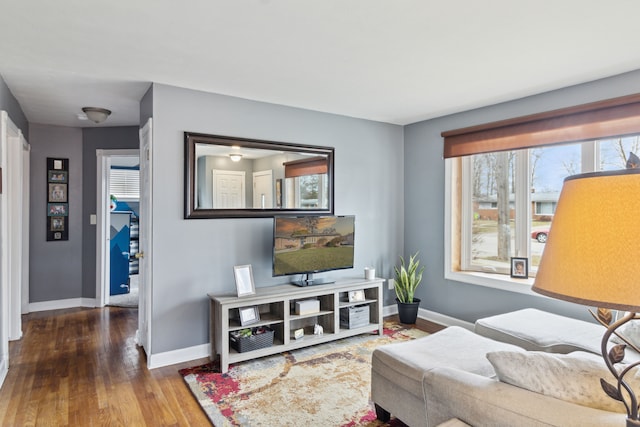 living area with baseboards and wood finished floors