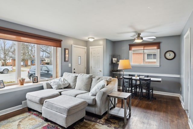 living area with hardwood / wood-style floors, a ceiling fan, and baseboards