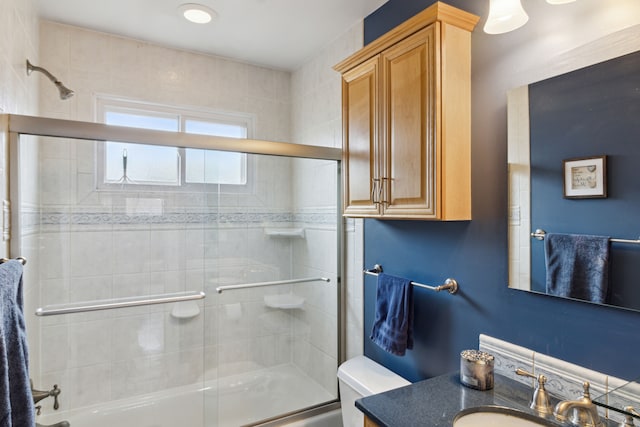 full bathroom featuring combined bath / shower with glass door, toilet, and vanity