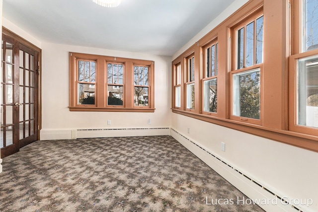 unfurnished sunroom with a baseboard heating unit and a healthy amount of sunlight