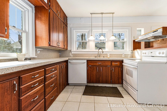 kitchen with white appliances, a sink, decorative backsplash, light countertops, and under cabinet range hood