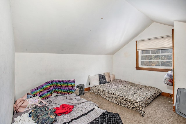 carpeted bedroom with baseboards and lofted ceiling