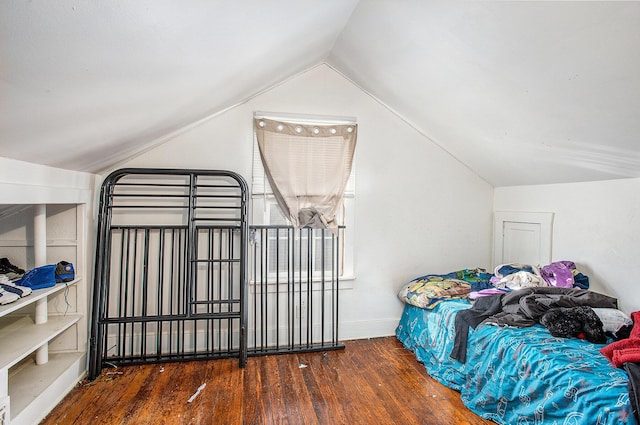 bedroom with vaulted ceiling, wood finished floors, and baseboards