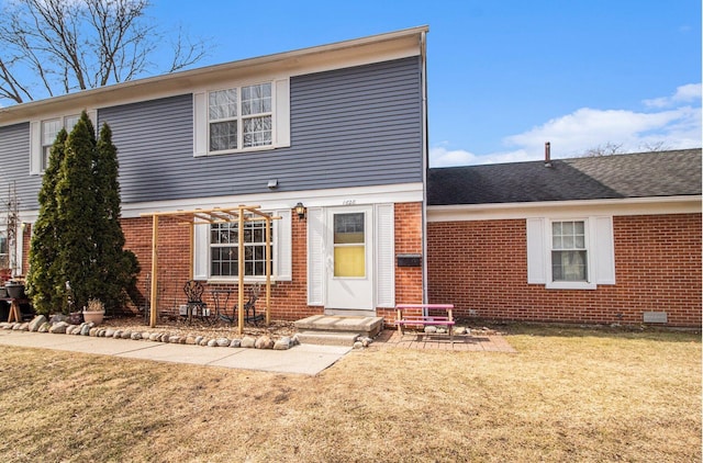 view of front facade with brick siding and a front lawn