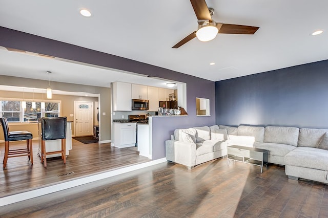 living room featuring recessed lighting, visible vents, dark wood-type flooring, and a ceiling fan