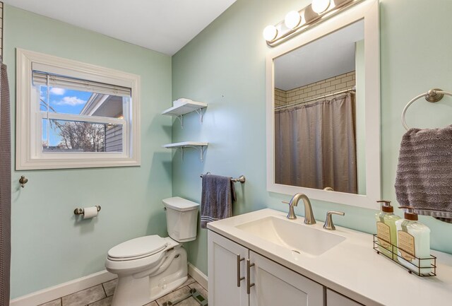 bathroom featuring tile patterned flooring, toilet, vanity, and baseboards