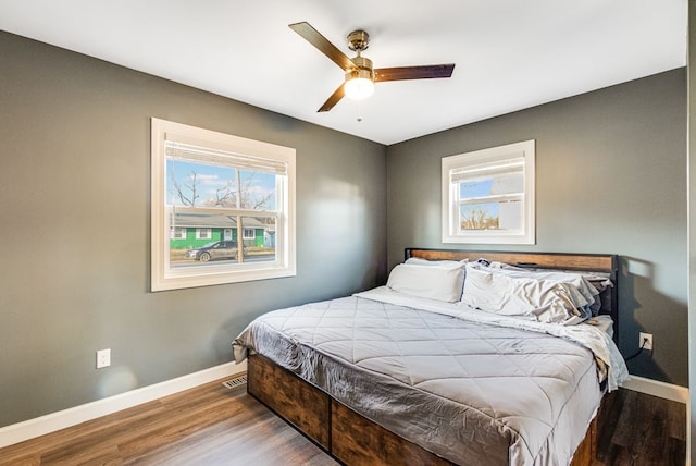 bedroom featuring baseboards, wood finished floors, and a ceiling fan