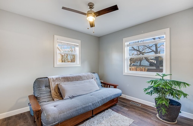 sitting room featuring visible vents, plenty of natural light, baseboards, and wood finished floors