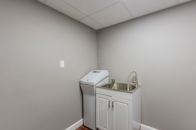 laundry room featuring cabinet space, baseboards, and a sink