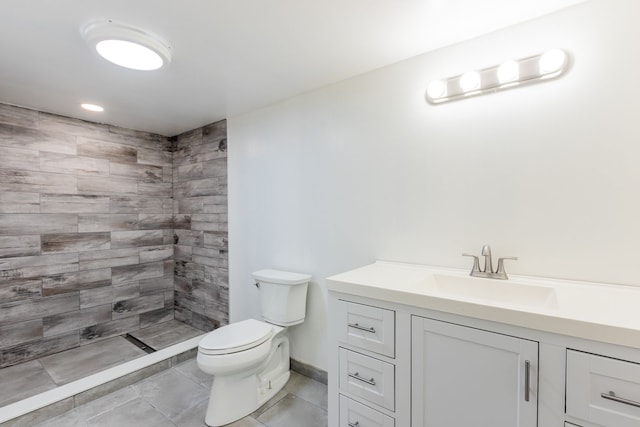 full bath with tile patterned flooring, baseboards, toilet, a tile shower, and vanity