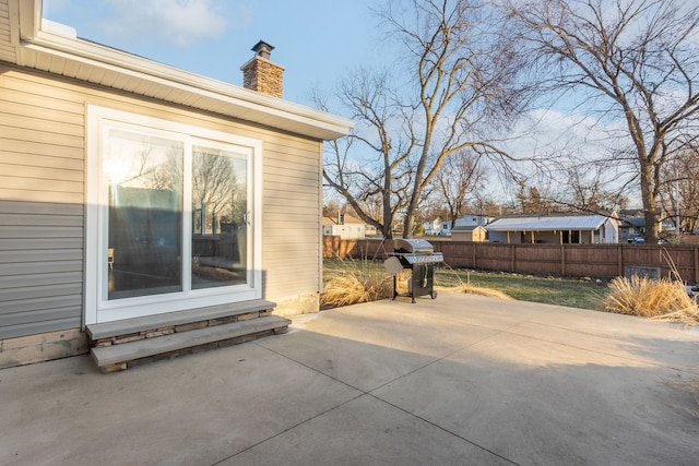 view of patio with area for grilling and fence