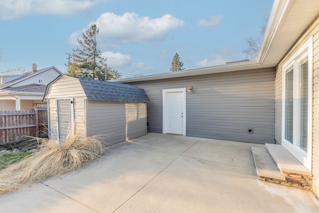 garage featuring a storage unit and fence