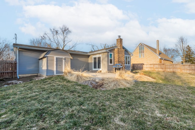 back of property featuring a lawn, a chimney, and fence