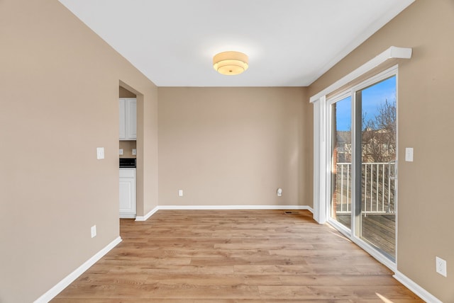 empty room featuring light wood finished floors and baseboards