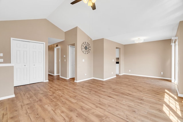 unfurnished living room with vaulted ceiling, light wood-style flooring, a ceiling fan, and baseboards