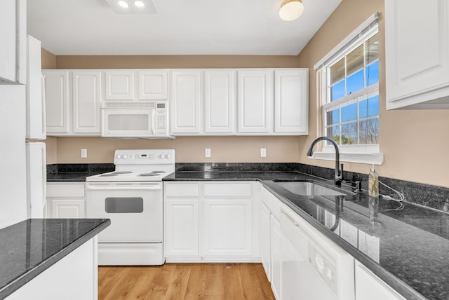 kitchen featuring a sink, light wood-type flooring, white appliances, and white cabinets