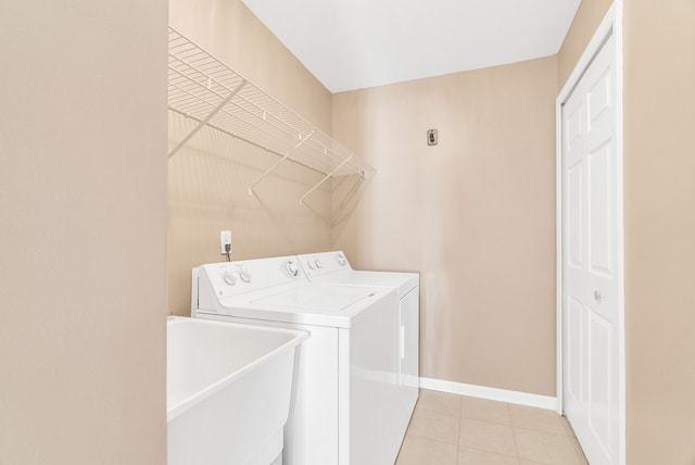 laundry room with light tile patterned floors, baseboards, laundry area, separate washer and dryer, and a sink