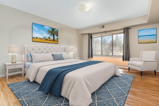 bedroom featuring visible vents, light wood-type flooring, and baseboards